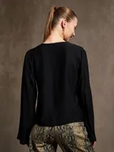 Blusa negra de mangas largas acampanadas con escote en V y lazo de ajuste en el frente.