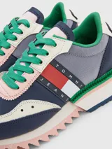 Zapatillas Tommy Jeans de cuero sintético color azul marino, gris y blanco, con cordones verdes y suela gruesa dentada en rosa y blanco.