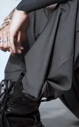 Pantalón gris de corte amplio con bolsillos laterales.