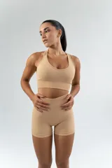Top deportivo color beige con breteles cruzados en la espalda.