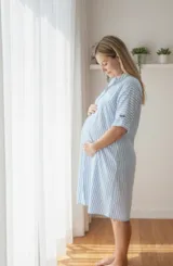 Camisola de maternidad y lactancia, color celeste con rayas blancas verticales. Diseño de camisa con cuello, manga corta y botones frontales.