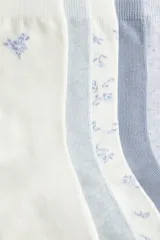 Pack de siete pares de medias de algodón en punto fino, con diseños lisos y estampados florales en tonos pastel.