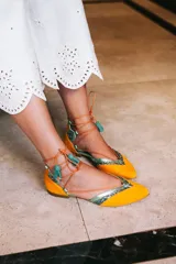 Bailarinas color naranja con detalles en celeste y glitter. Cuentan con cordones de algodón con borlas de ante, cuña interna de 1,5cm y suela de cuero. Incluyen plantilla de piel y plantilla extra de lana intercambiable.