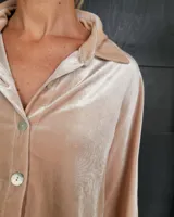 Camisa de terciopelo color marrón claro con cuello clásico, cierre frontal con botones y mangas largas con puños abotonados.