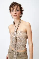 Top strapless color beige con estampado animal print metalizado y pañuelo a tono que se ata al cuello.