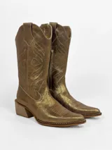 Bota tejana dorada de cuero con calado y bordado decorativo, taco bajo y caña media.