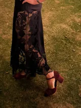 Zapato de tacón de terciopelo verde con correa al tobillo, punta redondeada y tacón cuadrado.