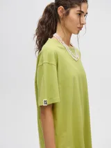 Remera amarilla de corte cuadrado y holgado, con estampado de estrella plateada con borde negro en el frente.