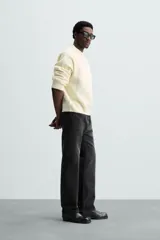 Jersey color crema de punto con textura, cuello redondo, manga larga y corte relaxed fit.