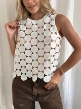 Top blanco sin mangas con cuello redondo y diseño calado con círculos.