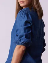Blusa de lyocell azul, marca Alex & Parker, con cuello a la base y escote en V. Manga ¾ con terminación fruncida.