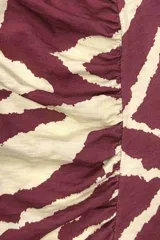 Falda midi de algodón con estampado de cebra en rojo y blanco, corte recto y abertura lateral.