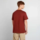 Remera color ladrillo con estampado frontal de la palabra "Toronto" en letras grandes con borde azul marino, un logo con la letra "T" y la palabra "Canada" en letras pequeñas.