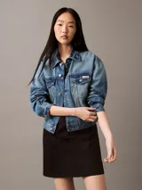 Vestido corto negro de popelín de algodón, corte evasé y diseño sin mangas. Tiene cremallera en la parte trasera central, está parcialmente forrado y cuenta con un bordado de Calvin Klein en la misma gama de tonos en el pecho.