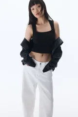 Musculosa negra de punto con escote cuadrado y ribete de picot en cuello y sisas.