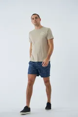 Short de baño azul con estampado de hojas y flores en blanco. Tiene cintura elástica con cordón ajustable, dos bolsillos laterales y uno trasero.