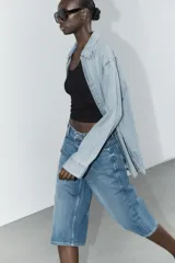 Bermuda jorts de denim celeste con efecto lavado, tiro bajo y cinco bolsillos. Cierre frontal con cremallera y botón metálico.