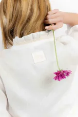 Blusa color blanco de lino, con mangas 3/4 y volados en el frente. Se ata con lazos en el centro.