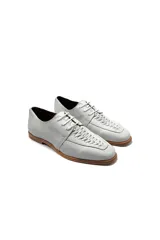 Zapatos de cuero blanco con diseño trenzado en la parte delantera y cordones.
