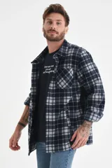 Sobrecamisa a cuadros azul marino y gris, de corte recto y manga larga, con cuello camisero y cierre frontal con botones.