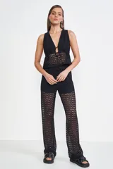 Blusa negra de crochet con escote en V y lazo ajustable en el centro.