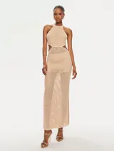 Vestido largo de tejido de punto color beige, con cuello halter y aberturas laterales. El tejido es calado con un patrón de pequeños rombos.