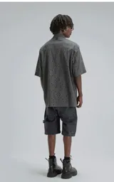 Camisa de manga corta, corte oversize, color negro con efecto desgaste. Confeccionada en algodón bordado (broderie) con diseño floral y calado.