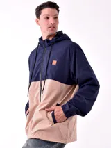 Campera con capucha azul marino y beige con cierre frontal y logo en el pecho.