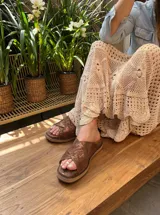 Sandalias marrones de cuero fantasía con plataforma baja. Hechas a mano en Uruguay.