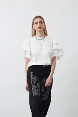 Remera negra de algodón con cuello redondo y mangas cortas con volados en capas.