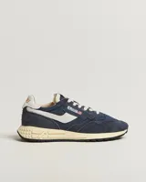 Zapatillas deportivas Autry modelo Reelwind Low, color azul marino con detalles en blanco crema. Presentan una combinación de nylon y gamuza, con la icónica estrella y el logo de Autry en el lateral. La suela es de goma en tono crema con detalles de estrellas en relieve en el talón.