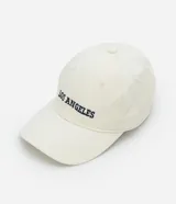 Gorra de sarga color crema con visera curva y bordado frontal con la frase "Los Angeles" en azul marino.