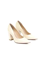 Stilettos de cuero charol color crema, con punta ligeramente redondeada y tacón geométrico de 10 cm.