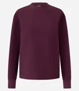 Sweater color borgoña de algodón con cuello redondo y mangas largas con ribete en los puños.