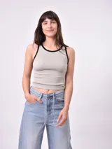 Musculosa negra de punto acanalado con cuello redondo y ribete blanco en cuello y sisas.