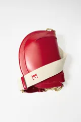 Bolso bandolera rígido color rojo, con asa corta y correa larga de tejido tipo canvas. Cierre con solapa e imán y bolsillo interior con cremallera.