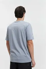 Remera celeste de manga corta con cuello redondo y estampado frontal con la frase "Slow Down You're Doing Fine" en letras blancas con efecto 3D.