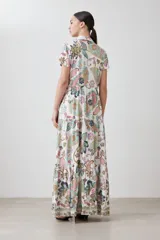 Vestido camisero largo de corte recto, con estampado de arabescos en tonos verde agua, rosa, marrón y gris. Tiene cuello camisero, mangas cortas y cierre frontal con botones.