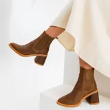 Botas cortas de cuero color marrón, con taco de madera forrado en cuero, elástico lateral y punta fina.