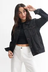 Campera de jean celeste de corte clásico, con cuello camisero, cierre frontal con botones metálicos negros, bolsillos con solapa abotonada en el pecho y bolsillos laterales.