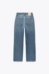 Pantalón de jean color crudo, de tiro alto, corte recto y largo tobillero. Tiene cinco bolsillos, cierre frontal con cremallera y botón metálico.