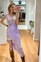 Vestido lila con estampado floral, escote en V, corte asimétrico y abertura en la cintura.