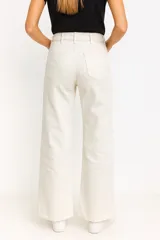Pantalón de jean color crudo, de corte recto y tiro alto, con bolsillos delanteros y traseros.