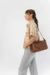 Bandolera moderna de eco cuero texturado color negro, con solapa frontal con cierre magnético oculto y correa regulable para llevar al hombro o cruzada.