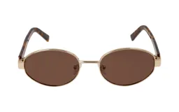 Lentes de sol con marco ovalado dorado y lentes marrones. Patillas de carey.