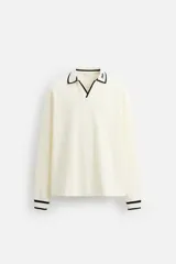 Polo color crema de corte relaxed fit, con cuello solapa con abertura frontal y manga larga. Presenta bordado combinado a contraste en cuello y acabados en rib.