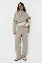 Buzo hoodie de frisa color beige, de silueta oversize, con puños y cintura de rib al tono, capucha forrada en su interior, bolsillo canguro, cordones con ojalillos y punteras metálicas personalizadas con marca, tanca para regular cordones, remaches en boca de bolsillo y bordado en espalda a contratono.