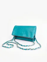 Cartera de cuero color celeste con textura croco y cadena metálica plateada.