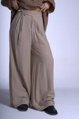 Pantalón de vestir color beige, de corte sastrero con tablas frontales y cintura con lazo.