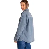 Chaqueta oversized de denim a rayas verticales azules y blancas, con cuello clásico, cierre frontal con botones metálicos, mangas largas con puños abotonados, dos bolsillos de parche en el pecho y bolsillos laterales.